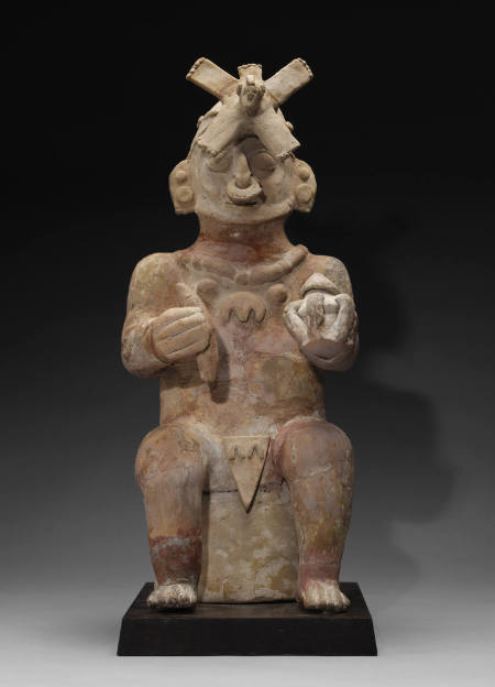 Seated male figure wearing an elaborate headdress