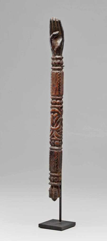 Wooden staff with carved human hand at one end