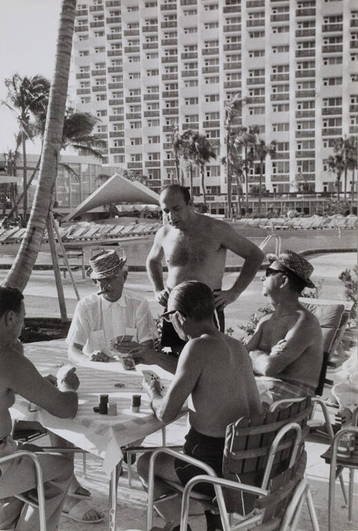 Men playing cards at poolside, USA