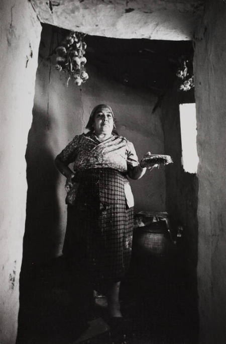 An old woman in Isnello shows off an award received for her handwoven rugs, Sicily, Italy