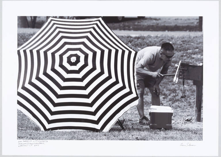 Man barbecuing with umbrella, Sherwood Island State Park, Westport, Connecticut
