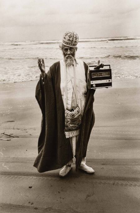 Bearded man with hat and radio on beach, Iran