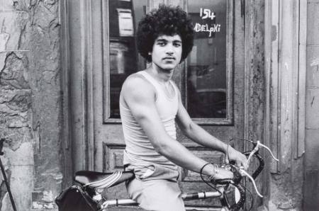 Victor and his bicycle in front of a door, from the series Teen Baby