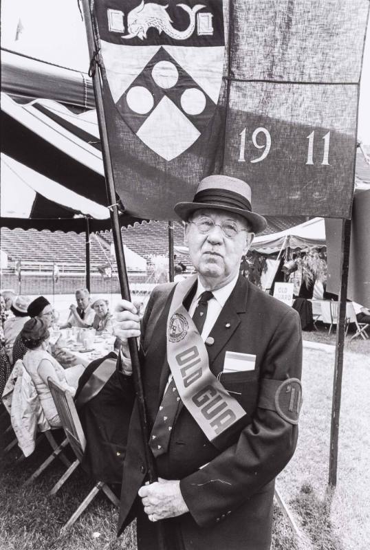 Man in hat holding a 1911 flag, UPenn alumni parade