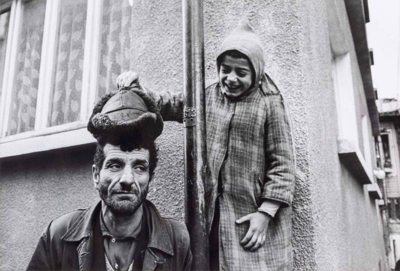 Girl lifting hat from man's head, Turkey