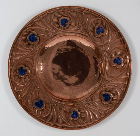 Plaque with floral pattern including blue colored, heart-shaped inlay