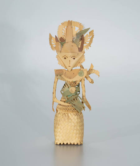 Cili figure with triangular head, feathered headdress, and green sash