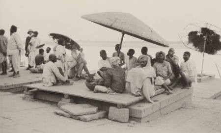 [Group of men under umbrella, India]