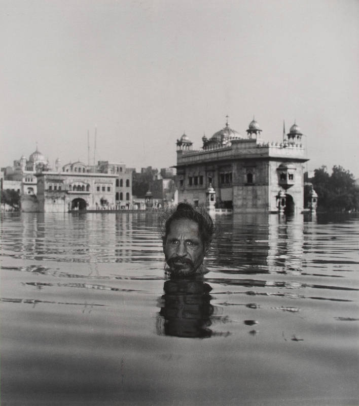 [The Sikh refreshes his body and soul in the sacred waters surrounding the Golden Temple]