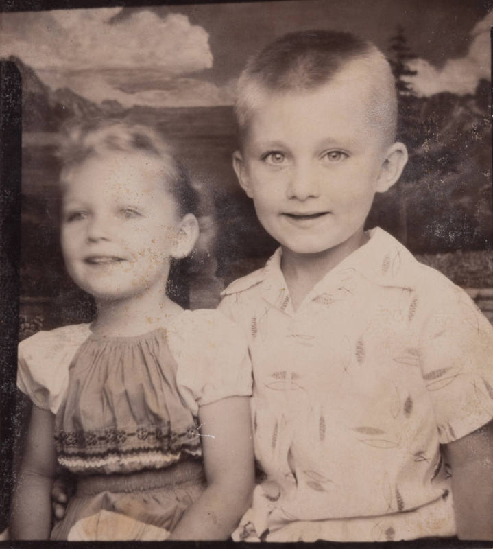 Photo booth portrait of a boy and girl: the boy looking at the camera while the girl looks afar