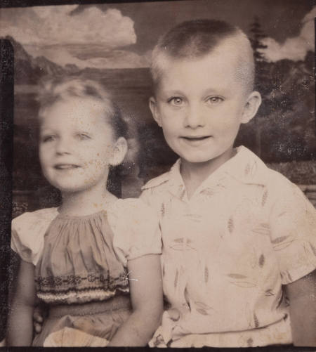 Photo booth portrait of a boy and girl: the boy looking at the camera while the girl looks afar