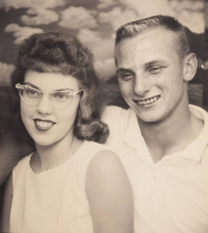 Photo booth portrrait of a young couple: the girl with long hair, wearing cat eye glasses and lipstick; boy with crewcut hairstyle