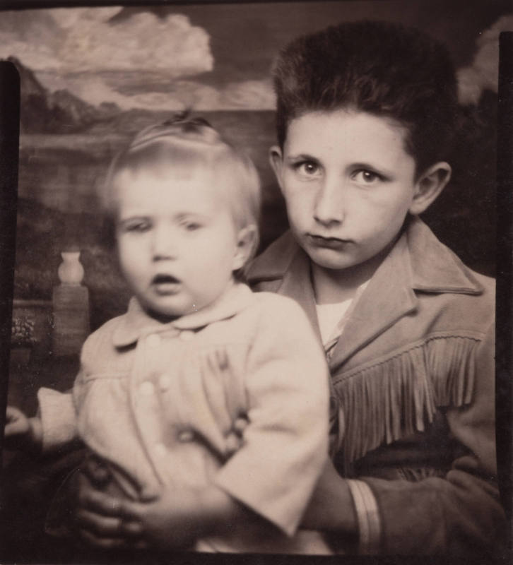 Photo booth portrait of a little boy holding a little girl under her arms
