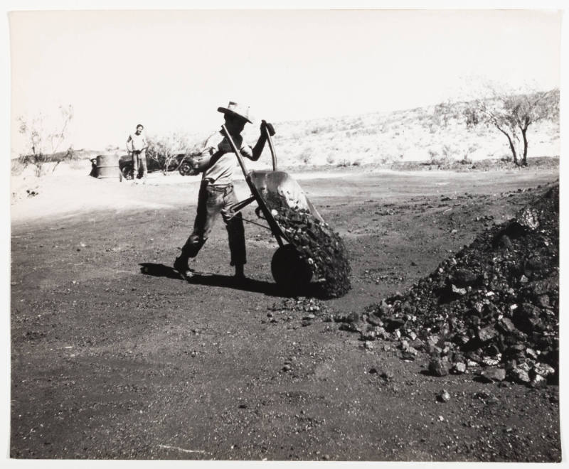 Untitled [Man emptying wheelbarrow]