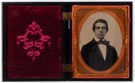 Untitled [Young, cleanshaven man in bowtie with cheeks and lips enhanced in red]
