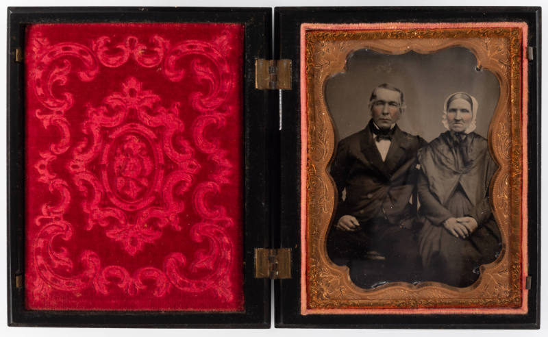 Untitled [Older couple, man with left arm around his wife, both with cheeks enhanced in red]