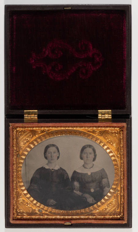 Untitled [Two young women, cheeks enhanced in red, jewelry painted in gold]
