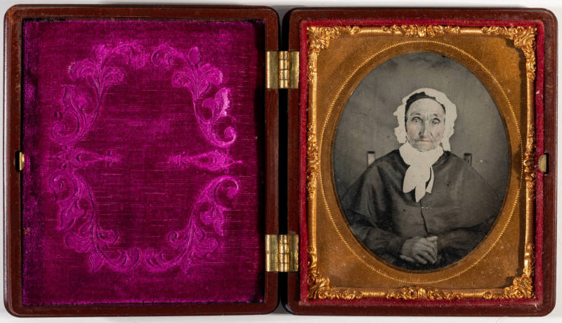 Untitled [Old woman in a white bonnet, hands clasped in lap]