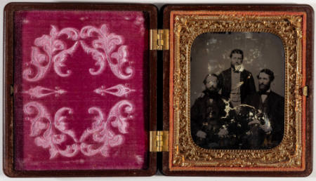 Untitled [Three men, two seated, man in middle standing]