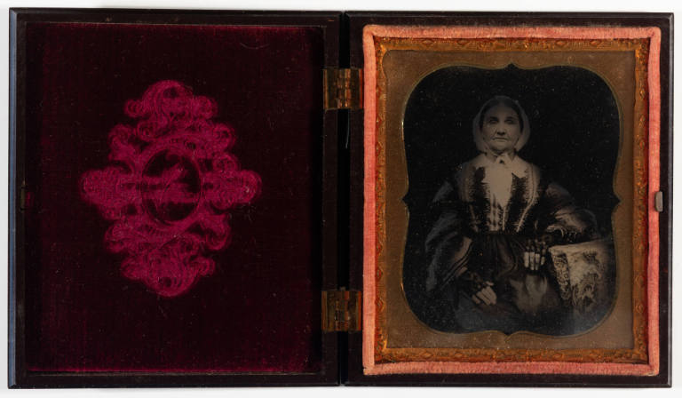 Untitled [Old woman in a bonnet with festive blouse and fingerless lace gloves, cheeks enhanced in red]