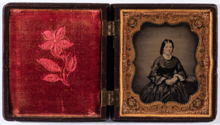 Untitled [Pretty young woman, hands clasped in lap, cheeks enhanced in red]