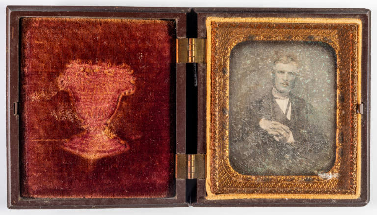 Untitled [Cleanshaven man seated sideways in chair]