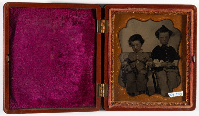 Untitled [Two little boys, seated in chairs, cheeks enhanced in red]