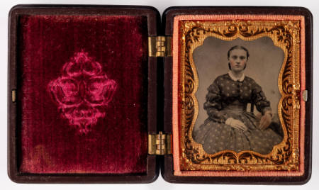 Untitled [Seated young woman, hands in lap, cheeks enhanced in red]