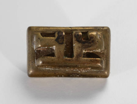 Rectangular goldweight decorated with raised motif resembling lower-case "h's," arranged back-to-back