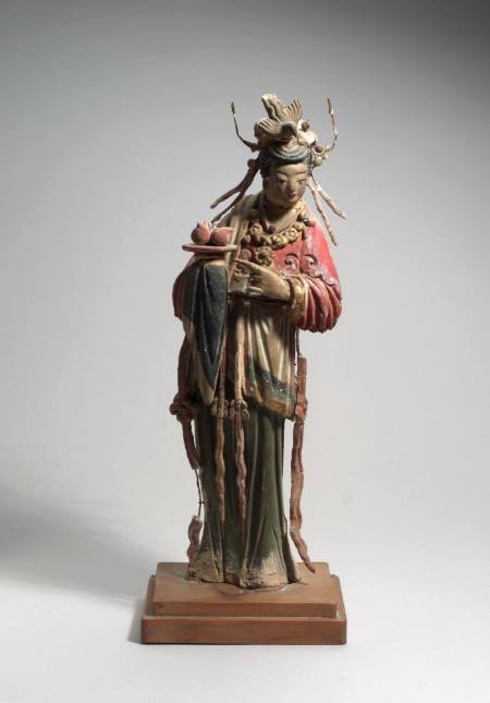 Figure of a woman carrying three peaches on a plate