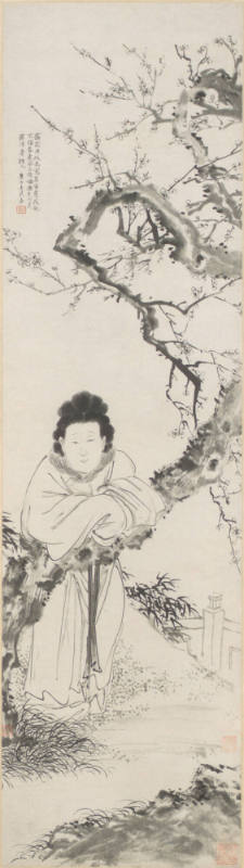Woman leaning against a blossoming plum tree