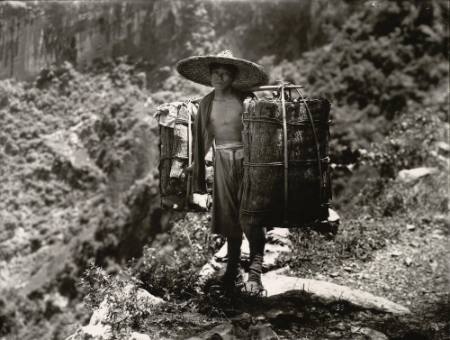 [Man carrying a load of bark]