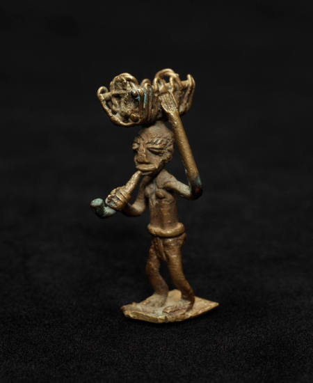 Goldweight of man smoking pipe with basket on head
