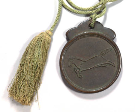 Flat plaque with a raised design of a dashing horse