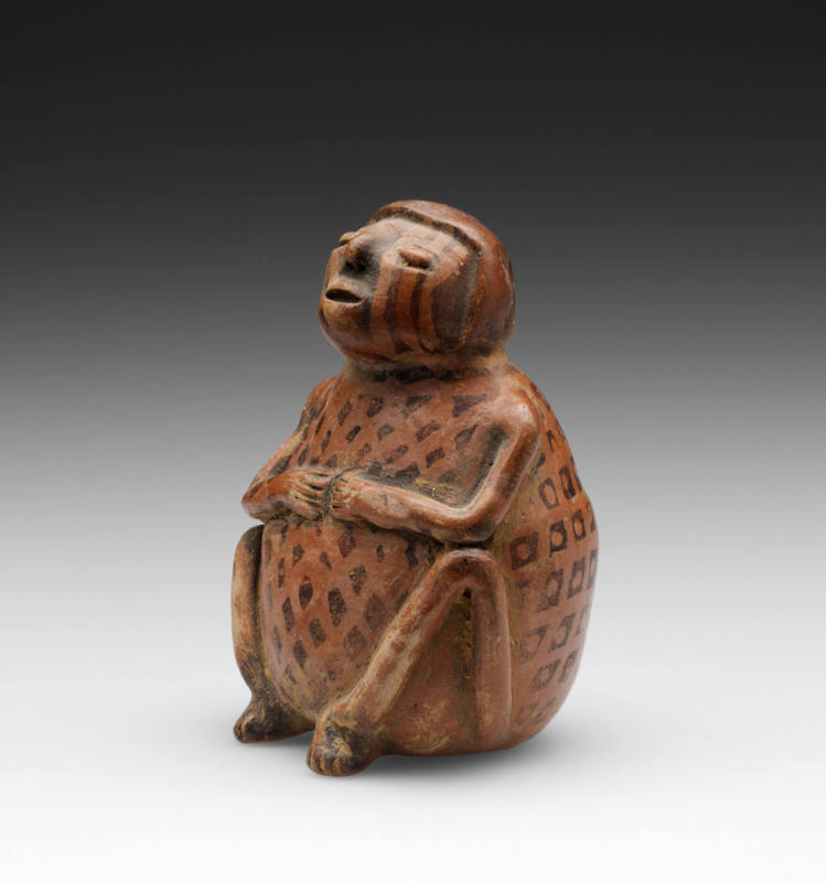 Seated person chewing coca (
