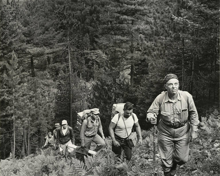 [Father Daniel Linehan leading a field crew through the Maine Woods to the Kennebec River to investigate by seismic methods the choice of a new dam site]