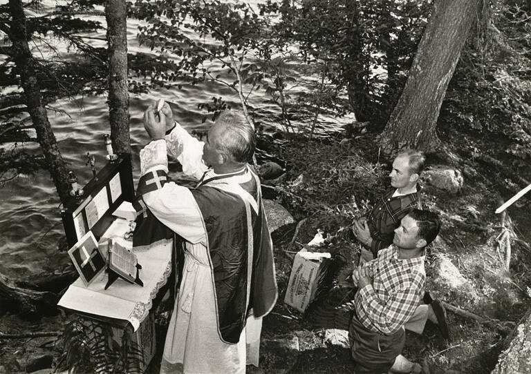 [Father Daniel Lineham offering Mass to field crew on dam site expedition to the Kennebec River]