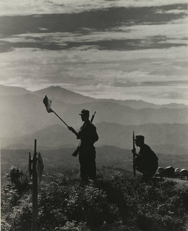 [Korean soldiers on mountain with flag]