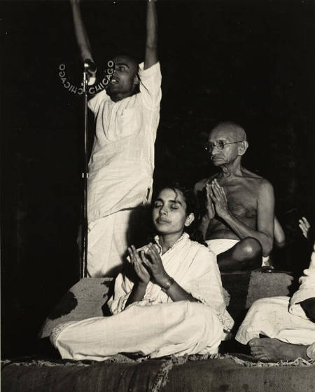 [Gandhi, his nephew Kanu, and his secretary Sushila Pai with Anis Ahmed, participating in twilight prayer]
