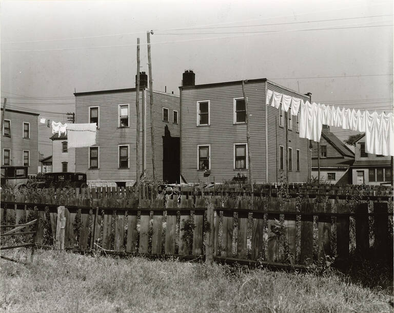 [Rear of row houses with laundry and automobiles, Newark, New Jersey]