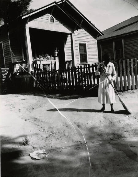 [Woman sweeping walkway]