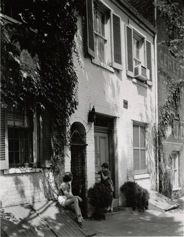 [Two girls talking outside house]