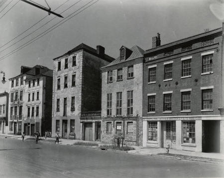 [Row of abandoned shops with children playing]