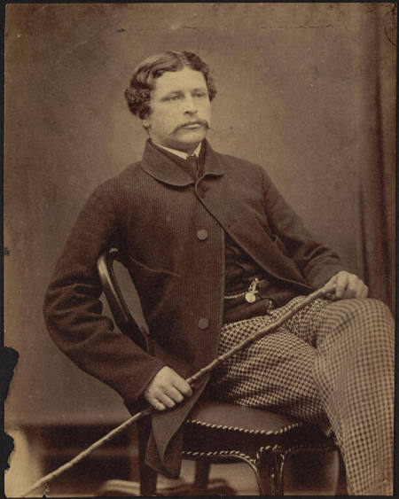 [Seated man wearing patterned pants]