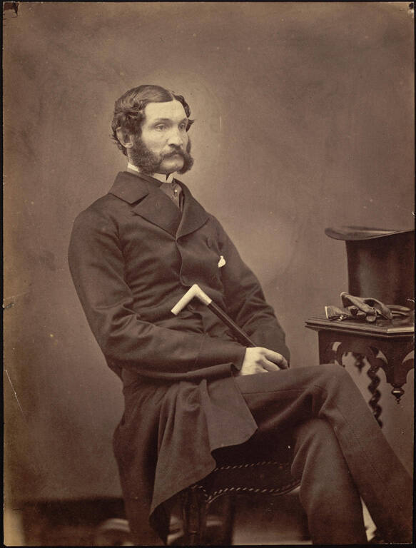 [Seated man with top hat and cane]