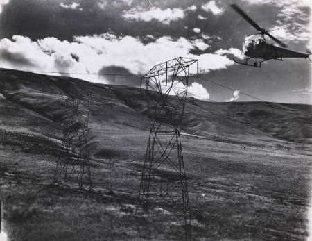 [Helicopter flying above power lines]