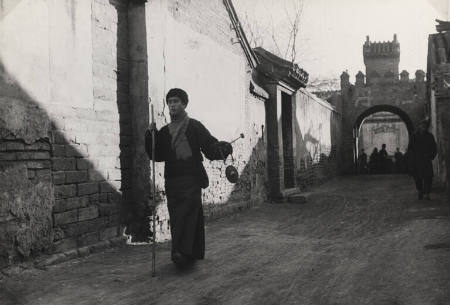 "Peiping Essay": Blind fortune teller carrying small gong as he seeks customers through the lanes of Peiping, China