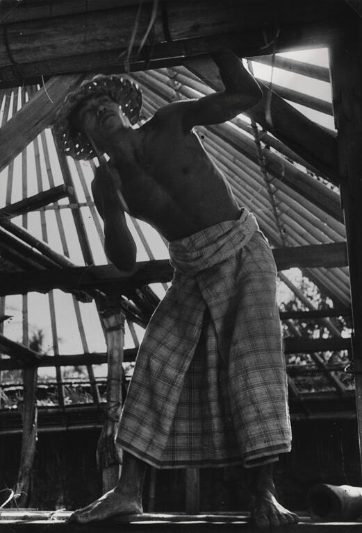 Man building a roof for a temple, Bali