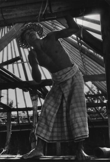 Man building a roof for a temple, Bali