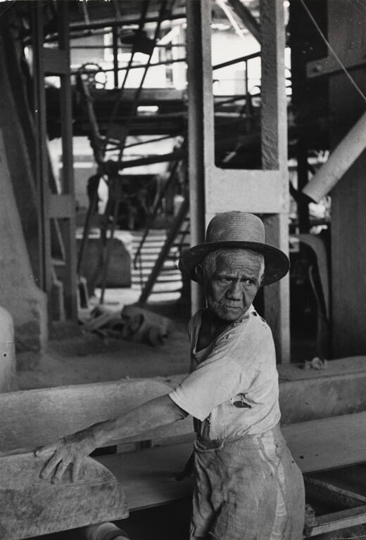 Old man in hat working in cement factory in Padang Sumatra